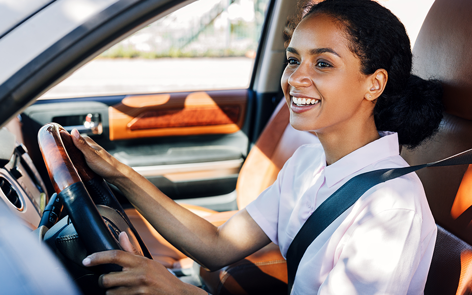 A woman is seated in the driver's seat of a car