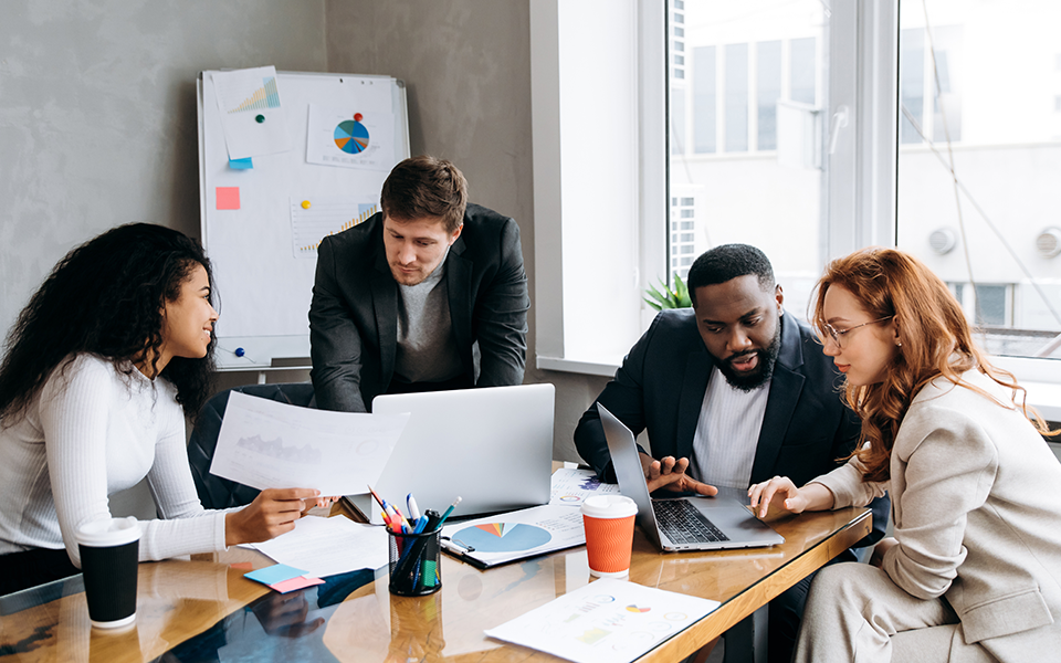 A group of people in a conference room on their computers