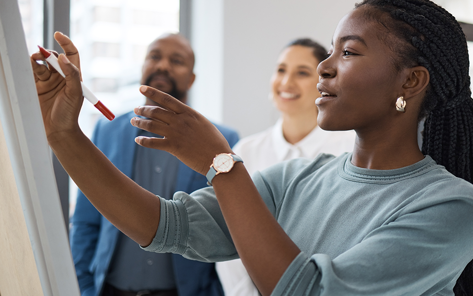 A woman is writing on a pad of paper on the wall