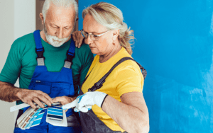 A man and woman look at color swatches to pick a paint color