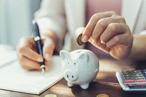 Woman putting change into a piggy bank