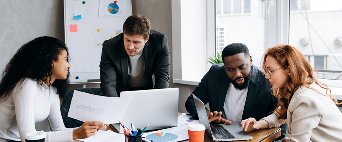 A group of people in a conference room on their computers