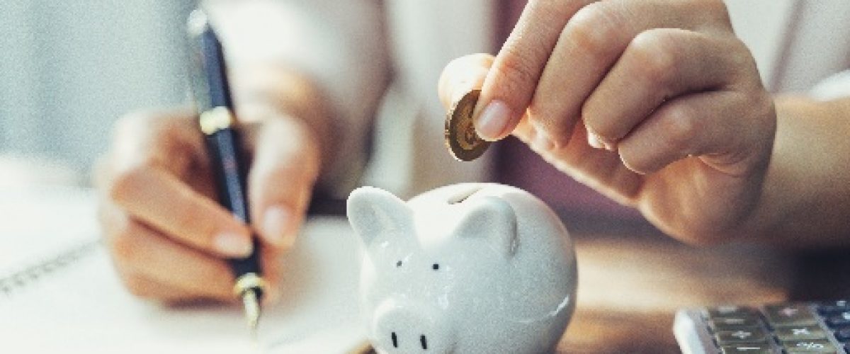 Woman putting change into a piggy bank